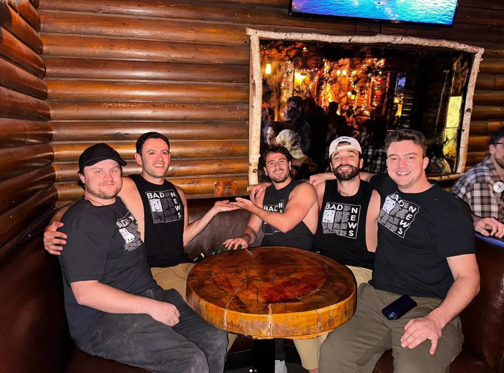 The five members of Bad News in matching Bad News shirts, crowded around a tree-stump table in a log-cabin booth at BigFoot West.